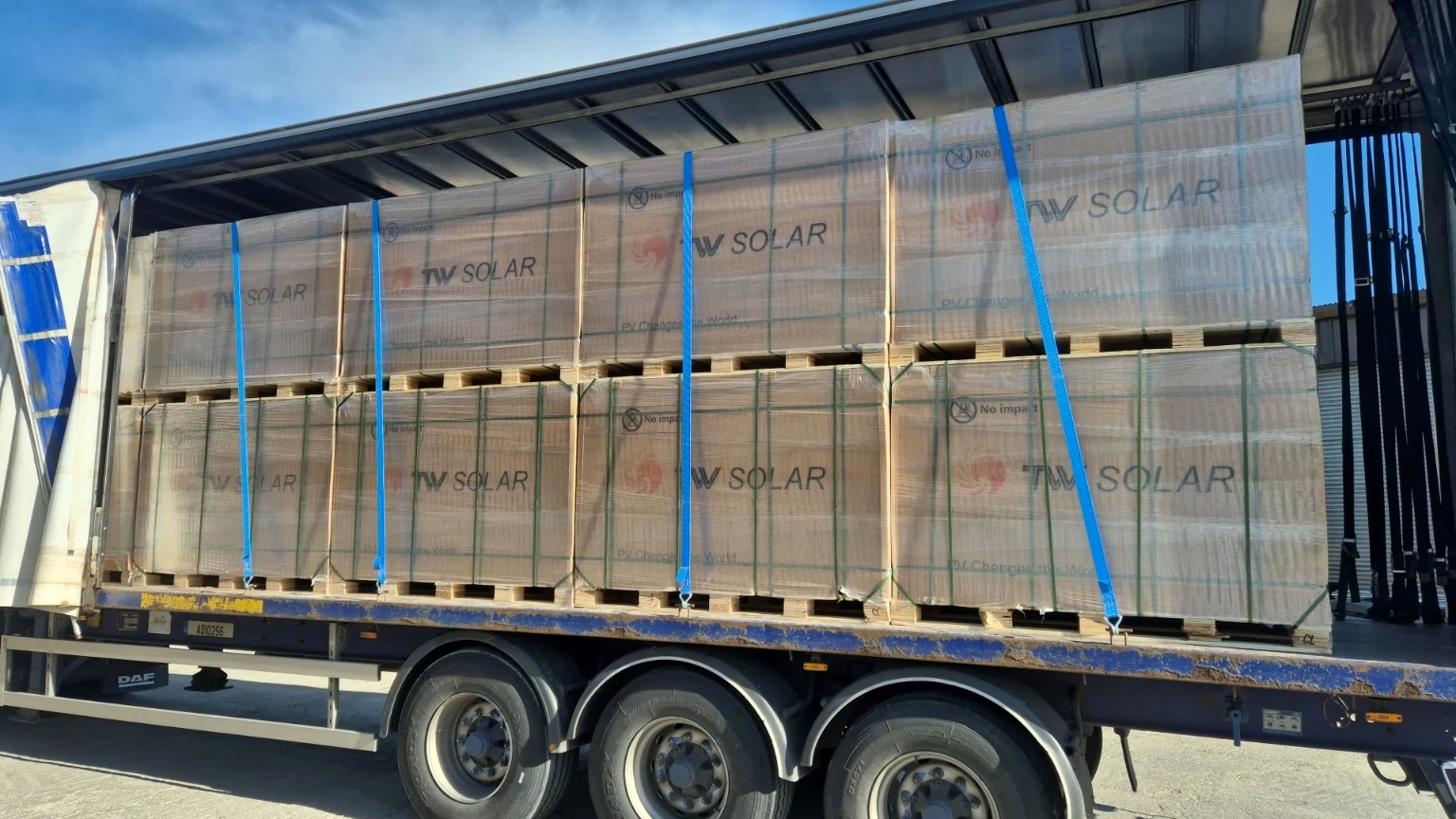 Wrapped equipment on a curtainsider trailer, with securing straps visible.