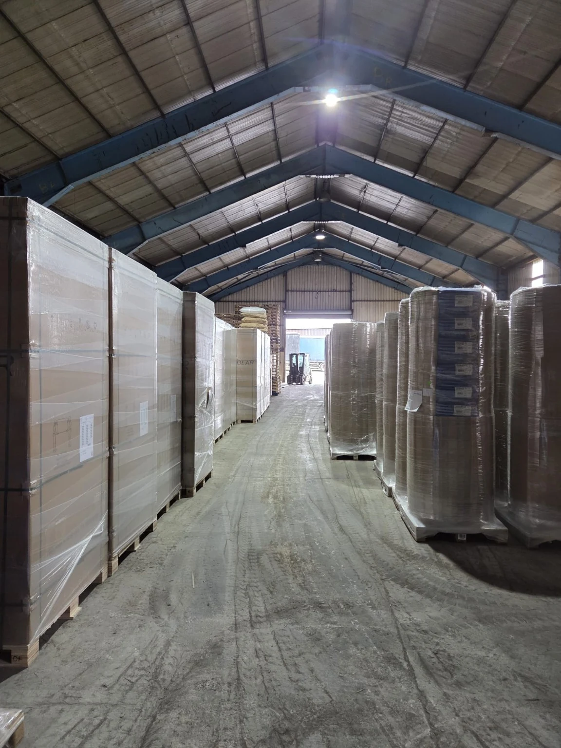 An aisle between stored, wrapped goods in the warehouse.